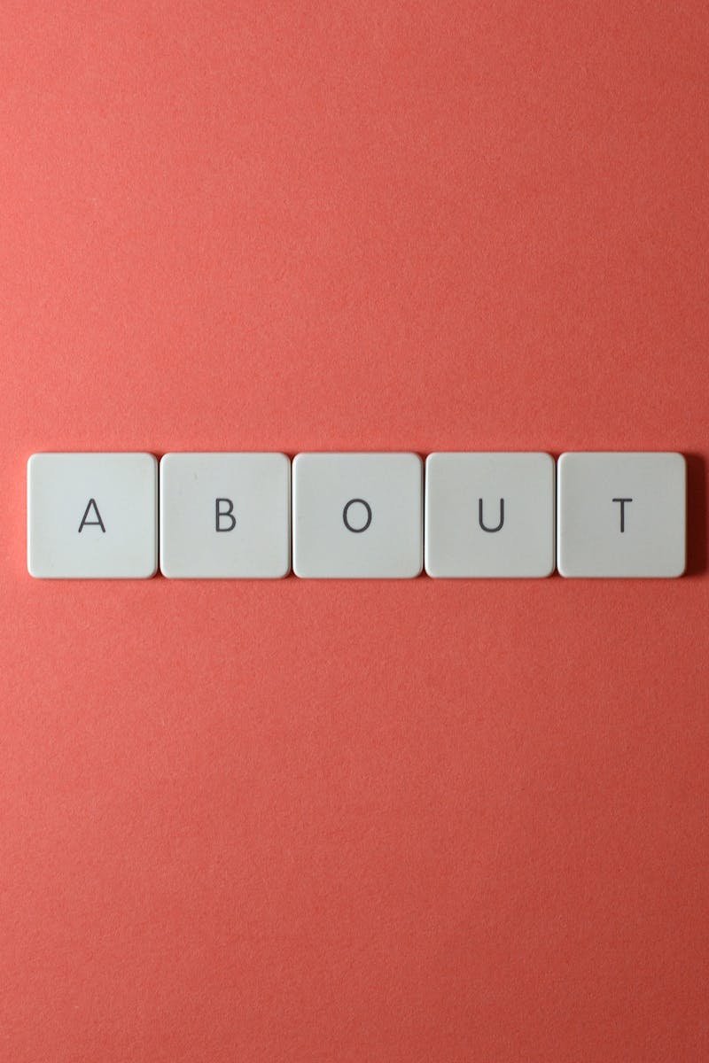 Close-up of keyboard buttons spelling 'ABOUT' against a red surface, minimalist style.